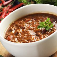 bowl of red hot chili with ground beef, beans and legumes.